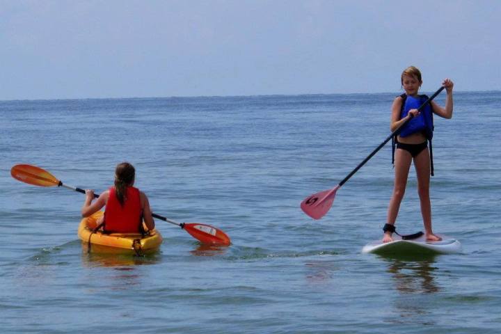 a young girl riding a wave on a surfboard in the water