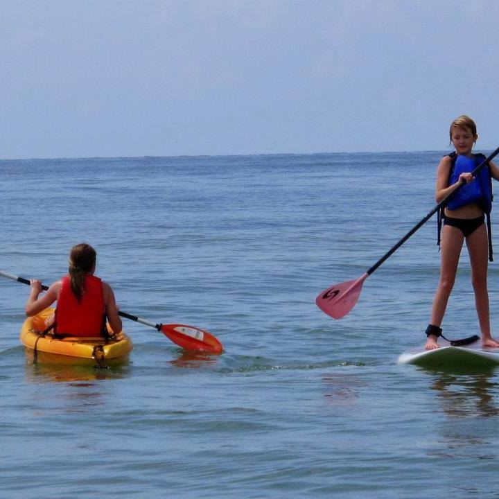 a young girl riding a wave on a surfboard in the water