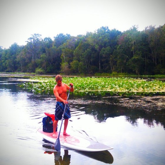 a man standing next to a body of water