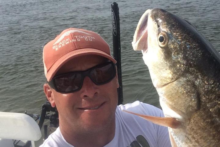 a man holding a fish in the water