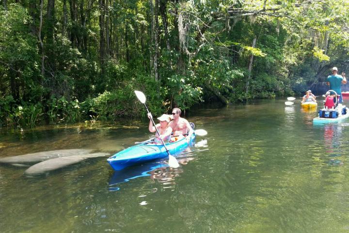 a group of people riding on the back of a boat in the water