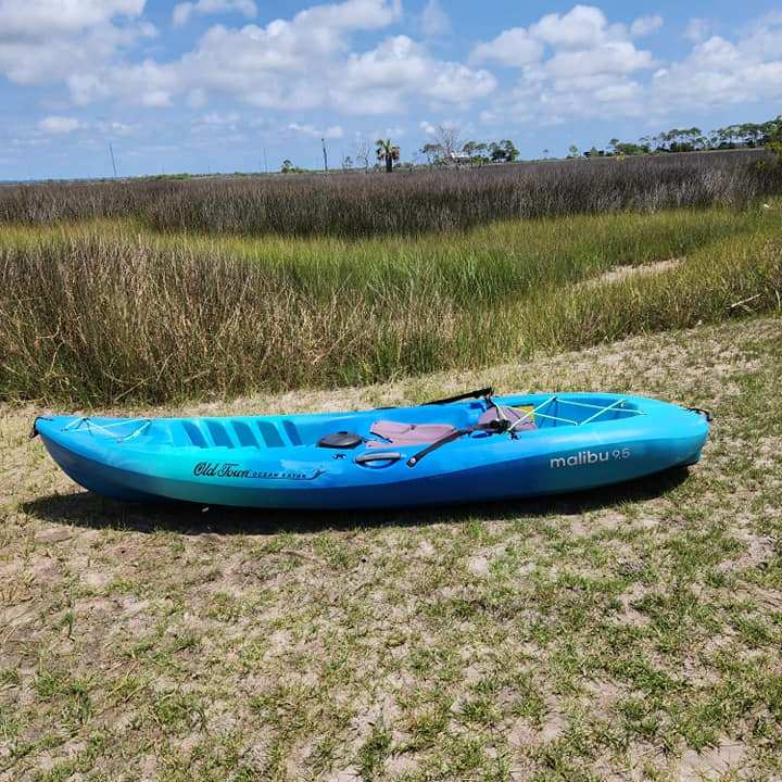 a blue boat sitting on top of a grass covered field